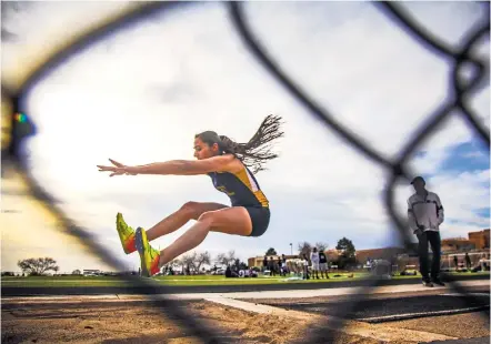  ?? GABRIELA CAMPOS/THE NEW MEXICAN ?? Riannah Varela, a sophomore at Santa Fe High School, competes in the triple jump Wednesday during the Golden Spike Classic at Santa Fe High School. Varela came in second in the event.