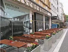  ?? RP-FOTO: PUVOGEL ?? Die Plakate zeigen Motive aus dem Inneren des Stadtbades an der Neusser Straße – nun ist davor ein Biergarten eingericht­et.