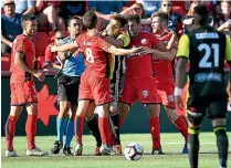  ??  ?? Wellington Phoenix midfielder Mandi, centre, is confronted by Adelaide United players after his kick on Vince Lia, second from right.