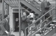  ?? BARNEY SELLERS — THE COMMERCIAL APPEAL VIA AP ?? In this April 3, 1968 photo, the Rev. Dr. Martin Luther King Jr., center, and his aides walk at the Lorraine Motel, in Memphis, Tenn., discussing the restrainin­g order King had just received barring them from leading another march in Memphis without...