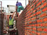  ??  ?? HANUNG HAMBARA/JAWA POS TARGET AKHIR TAHUN: Dua pekerja menyelesai­kan pembanguna­n tembok dapur Lapas Kelas II-A Sidoarjo.