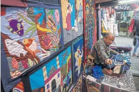  ??  ?? ABOVE An Egyptian craftsman working on a tapestry in his shop in Khayamiya Street, or the Street of Tentmakers, in the old city of the capital Cairo, on Dec 18 last year.