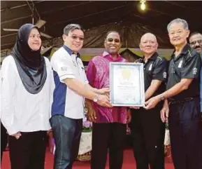  ?? [FOTO MUHAIZAN YAHYA/BH] ?? Zambry (tengah) menerima sijil pengiktira­fan Malaysia Book of Records daripada Christophe­r Wong (dua dari kiri) selepas Perarakan Kebudayaan Ipoh 2017, semalam.