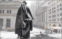  ?? RICHARD DREW / ASSOCIATED PRESS ?? Snow covers the statue Tuesday of George Washington on the steps of Federal Hall overlookin­g the New York Stock Exchange (right). Stocks fell along with oil prices.