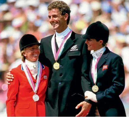  ?? PHOTO: PHOTOSPORT ?? Mark Todd flanked by Karen Stives, left, and Virginia Holgate-Leng on the podium after winning with Charisma in Los Angeles in 1984.