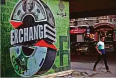  ?? Bloomberg ?? A currency exchange in Cairo. Analysts still do expect to see some devaluatio­n over the coming months.