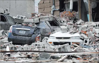  ?? Charlie Neibergall ?? The Associated Press Vehicles are covered in rubble from a tornado-damaged building Friday in Marshallto­wn, Iowa. Several buildings were damaged Thursday evening by a tornado in the main business district in town including the historic courthouse.