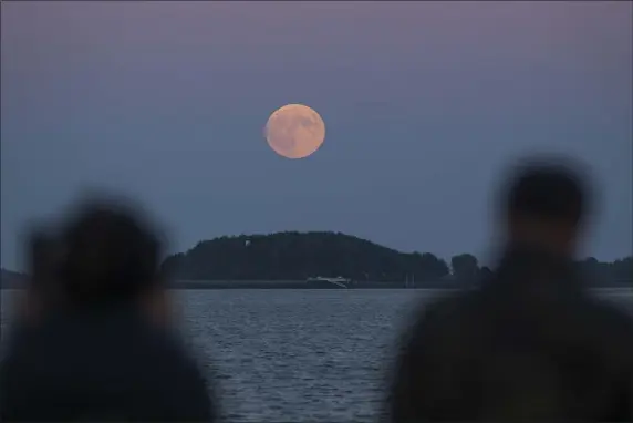  ?? SCOTT EISEN — GETTY IMAGES ?? We’ll see four supermoons this year, the first in July. Here, People view the Super Blood Moon from Castle Island on September 27, 2015 in Boston,
