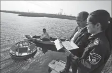  ?? XIE HAO / FOR CHINA DAILY ?? Technician­s check real-time water quality data via a collection device in Qingdao, Shandong province, in 2018.