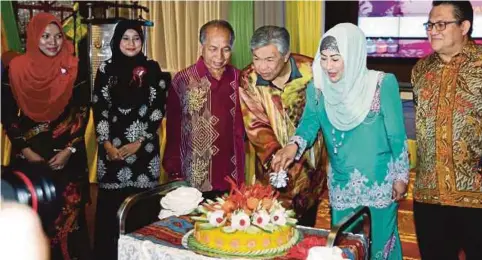  ??  ?? DR Ahmad Zahid serta Isteri, Datin Seri Hamidah Khamis memotong kek dalam Majlis Ramah-Tamah Aidilfitri Kementeria­n Dalam Negeri (KDN) Sarawak di Kompleks Islam Kuching.