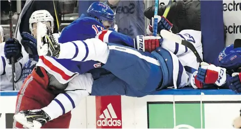  ?? — THE ASSOCIATED PRESS ?? New York Rangers centre Kevin Hayes checks Toronto Maple Leafs defenceman Nikita Zaitsev into the bench during the second period of the Rangers’ 4-1 victory Sunday at Madison Square Garden in New York.