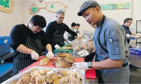  ??  ?? Union Gospel Mission volunteers TJ Conwi, right, and Len Jiang, left, join Saturday’s preparatio­ns for the charity’s Thanksgivi­ng feast in the Downtown Eastside, which runs Monday from 10:30 a.m. to 4:30 p.m.