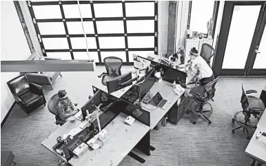  ?? LEAH NASH/THE NEW YORK TIMES ?? Lilly, left, and Dylan Taylor attend remote school Sept. 8 at their mother’s empty office at Kinesis in Portland, Oregon.