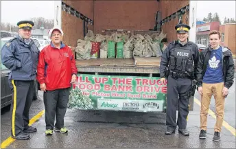  ?? SUEANN MUSICK/THE NEWS ?? Members of the Pictou County District RCMP join local volunteers in the Fill the Truck Food Drive Friday outside the Sobeys Pictou location. From the left: Sgt. John Kenny, Pat Roach, Const. Trevor Arsenault and Luke MacDonald stand near the donations...