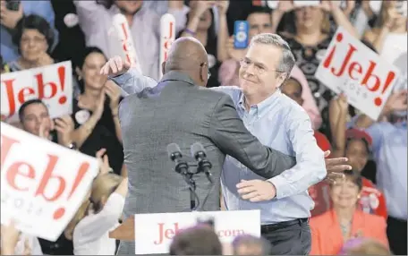  ?? Lynne Sladky
Associated Press ?? REPUBLICAN PRESIDENTI­AL candidate Jeb Bush, right, is embraced by the Rev. R.B. Holmes Jr. as Bush announces his candidacy Monday at Miami Dade College. Bush, who is bilingual, comes closer to the new Florida and the new America than many candidates.