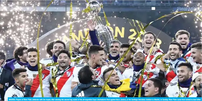  ??  ?? MADRID: Players of River Plate celebrate with the trophy after winning the second leg match of the all-Argentine Copa Libertador­es final against Boca Juniors, at the Santiago Bernabeu stadium in Madrid, on Sunday. River Plate came from behind to beat bitter Argentine rivals Boca Juniors 3-1 in extra time. — AFP