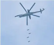  ??  ?? A Syrian army helicopter drops bombs on a rebel-held area at the weekend. It came after a US strike on a Syrian airbase last week