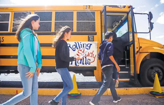  ?? GABRIELA CAMPOS/NEW MEXICAN FILE PHOTO ?? Students from Milagro Middle School board a school bus that is equipped with Wi-Fi. It allows students to study on long commutes home.