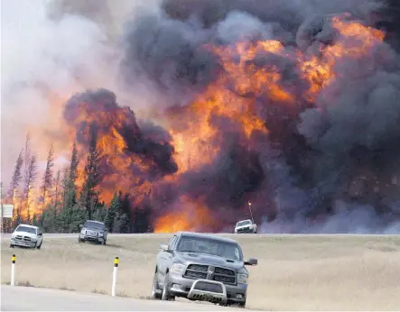  ?? JONATHAN HAYWARD/THE CANADIAN PRESS/FILES ?? A giant fireball is seen as a wildfire rips through the forest 16 km south of Fort McMurray on May 7, 2016. Mental health issues for residents and first-responders to the wildfires can continue for years after the event, say health experts.