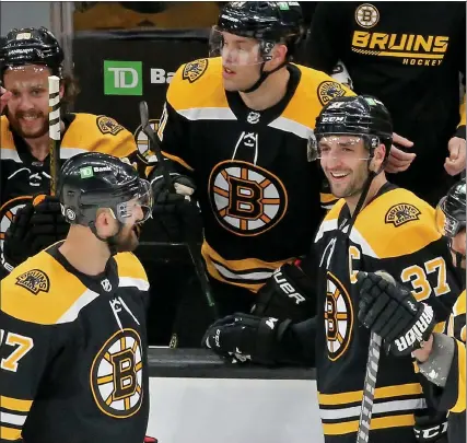  ?? STUART CAHILL / BOSTON HERALD ?? Bruins center Patrice Bergeron celebrates after recording a hat trick and his 400th career goal during Thursday’s win over the Sabres.