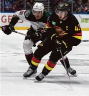  ?? Ethan Cairns/Associated Press ?? The Arizona Coyotes’ Josh Doan and the Vancouver Canucks’ Quinn Hughes during the first period on April 10 in Vancouver, British Columbia.