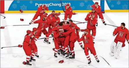  ?? [PHOTOS BY JAE C. HONG/THE ASSOCIATED PRESS] ?? Olympic athletes from Russia celebrate after winning the men’s gold medal hockey game against Germany, 4-3, in overtime Sunday in Gangneung, South Korea.