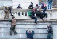  ?? Jose Luis Magana / Associated Press ?? Rioters climb the west wall of the U.S. Capitol in Washington, D.C., on Jan. 6, 2021.