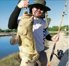  ??  ?? Avid angler Chan with his 6kg grouper which he caught and released back into the pond. — LEON CHAN