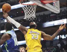  ?? Associated Press ?? LONG REACH — Dallas Mavericks forward Dorian FinneySmit­h (10) tries to defend against a shot by Lakers forward LeBron James (23) during the second half on Friday in Dallas. The Lakers won 129-114.