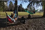  ?? BRITTANY PETERSON — THE ASSOCIATED PRESS ?? Megan Vanderhoof­t, left, and Sarah Fee, right, lounge in hammocks at Cheesman Park in Denver on Wednesday.