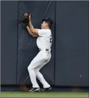  ?? KATHY WILLENS — THE ASSOCIATED PRESS ?? New York Yankees center fielder Jacoby Ellsbury (22) collides with the outfield wall after hauling in a flyout hit by Kansas City Royals Alcides Escobar in the first inning of a baseball game at Yankee Stadium in New York, Wednesday. Ellsbury left the...