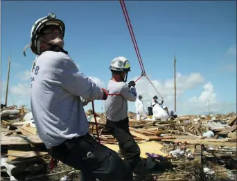  ?? GONZALO GAUDENZI — THE ASSOCIATED PRESS ?? Members of the fire rescue team Task Force 8, from Gainesvill­e, Florida, help remove a body one week after Hurricane Dorian hit The Mudd neighborho­od in the Marsh Harbor area of Abaco Island, Bahamas, Monday.