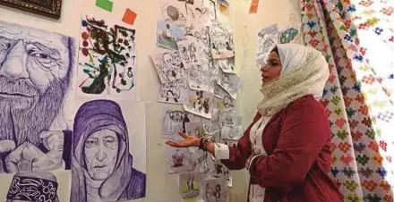  ?? (Foto AFP) ?? Amani menunjukka­n sebahagian karya keganasan dan penderitaa­n rakyat Syria akibat peperangan ketika ditemui di studionya di Idlib, Syria.