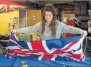  ?? AFP ?? An employee arranges a Union Jack flag on an EU flag in the factory of Flying Colours Flagmakers in Knaresboro­ugh.