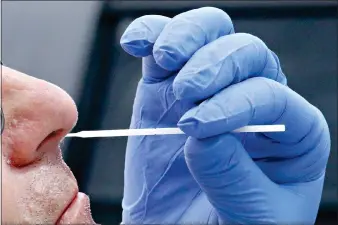  ?? (AP Photo/Rick Bowmer, File) ?? A nurse uses a swab to perform a coronaviru­s test June 12 in Salt Lake City. On Friday, The Associated Press reported on stories circulatin­g online questionin­g why an invasive nasal is necessary if COVID-19 spreads so easily through droplets. The answer is simple: Nasal swabs allow for a sample to be taken where the respirator­y virus lives. The coronaviru­s death toll in the U.S. surpassed 200,000 this week.