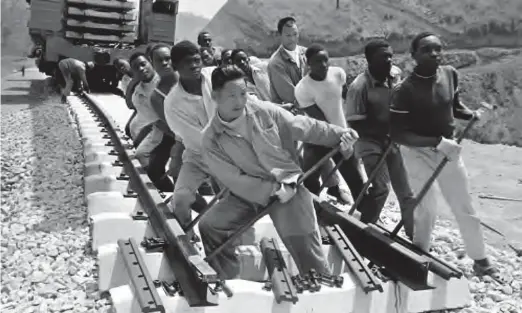  ??  ?? Chinese and African workers laying rail track