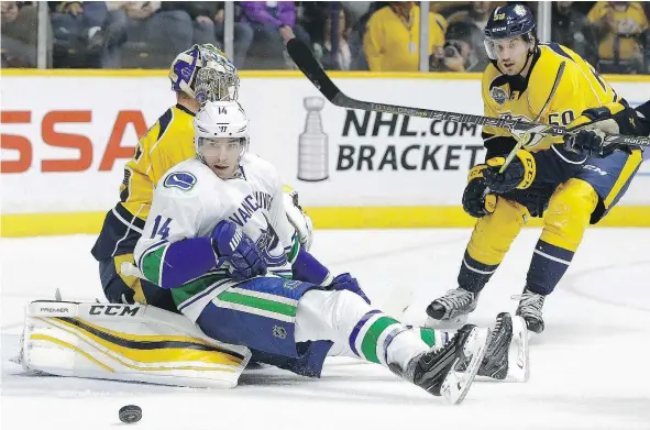  ?? — THE ASSOCIATED PRESS FILES ?? Canucks winger Alex Burrows lands on Nashville Predators goalie Pekka Rinne as Roman Josi chases the puck.