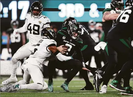  ?? Dustin Satloff / Getty Images ?? The New York Jets’ Zach Wilson is sacked by the Jacksonvil­le Jaguars’ Andre Cisco during the first quarter at MetLife Stadium on Thursday in East Rutherford, N.J.