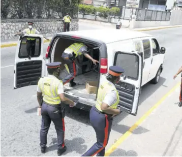  ?? (Photo: Naphtali Junior) ?? Police searching a vehicle on Eastwood Park Road in St Andrew on April 1, 2021.