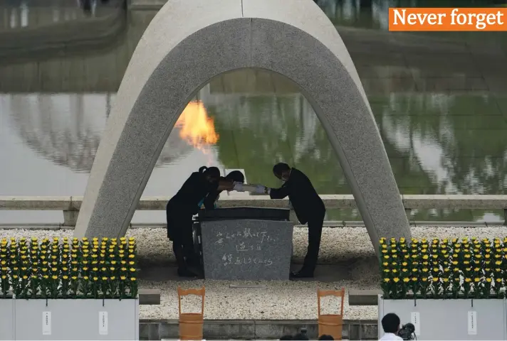  ?? Photo: AP ?? Kazumi Matsui, right, mayor of Hiroshima, and the family of the deceased bow before they place the victims list of the Atomic Bomb at Hiroshima Memorial Cenotaph during the ceremony to mark the 75th anniversar­y of the bombing at the Hiroshima Peace Memorial Park yesterday, in Hiroshima, western Japan.