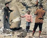  ?? Picture: REUTERS ?? THIS IS COLOSSAL: Youngsters from Matariya in Cairo pose with the head of an unearthed 8m statue that is said to depict Pharaoh Ramses II