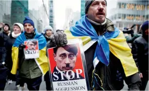  ?? AFP ?? HYPER SENSITIVE… A man holds a sign in protest against the Russian military interventi­on in the Crimea region of Ukraine, in New York City. —