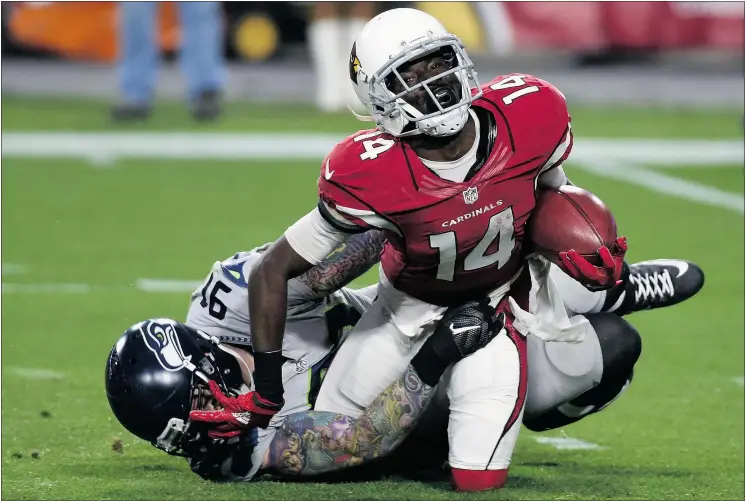  ?? — GETTY IMAGES ?? Arizona Cardinals wide receiver J.J. Nelson, front, is tackled by Seattle defensive end Cassius Marsh Sunday during the Seahawks’ 36-6 win in Glendale, Ariz.