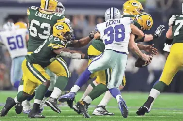  ?? GETTY IMAGES ?? Aaron Rodgers says his big hands helped him keep his grip on the ball after he was blindsided by the Cowboys’ Jeff Heath during the final drive in the fourth quarter on Sunday.