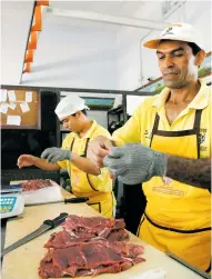  ?? ARCHIVO ?? Vendedores preparando carne de res para el comercio.