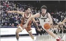  ?? PHOTO/YOUNG KWAK
AP ?? Gonzaga forward Drew Timme, right, drives to the basket while pressured by Texas forward Brock Cunningham during the second half of an NCAA college basketball game Saturday in Spokane, Wash.