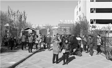  ??  ?? People stand in front of the main gate of the RYB Education New World kindergart­en in Beijing. — AFP photo