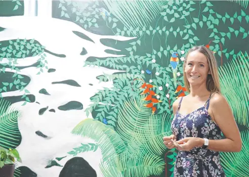  ?? Picture: GIZELLE GHIDELLA ?? BRIGHTEN UP: Port Douglas artist Kate Cooper with her colourful mural in Port Explorers Cooya Beach.