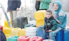  ?? — AFP ?? Palestinia­n children collect water at Zaytoun neighbourh­ood in Gaza City.