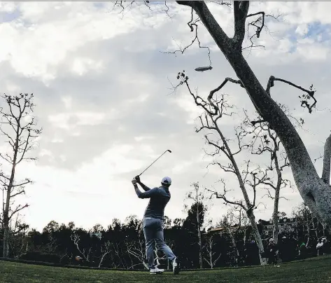  ?? PHOTOS: ROBERT LABERGE/GETTY IMAGES ?? Dustin Johnson plays his shot from the 16th tee during the final round at the Genesis Open at Riviera Country Club on Sunday in Pacific Palisades, Calif. The 32-year-old took over the top spot in the world golf rankings after winning the tournament.